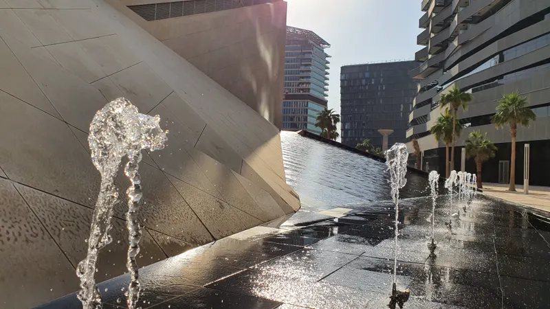 Fountain jets beside a water wall at KAFD