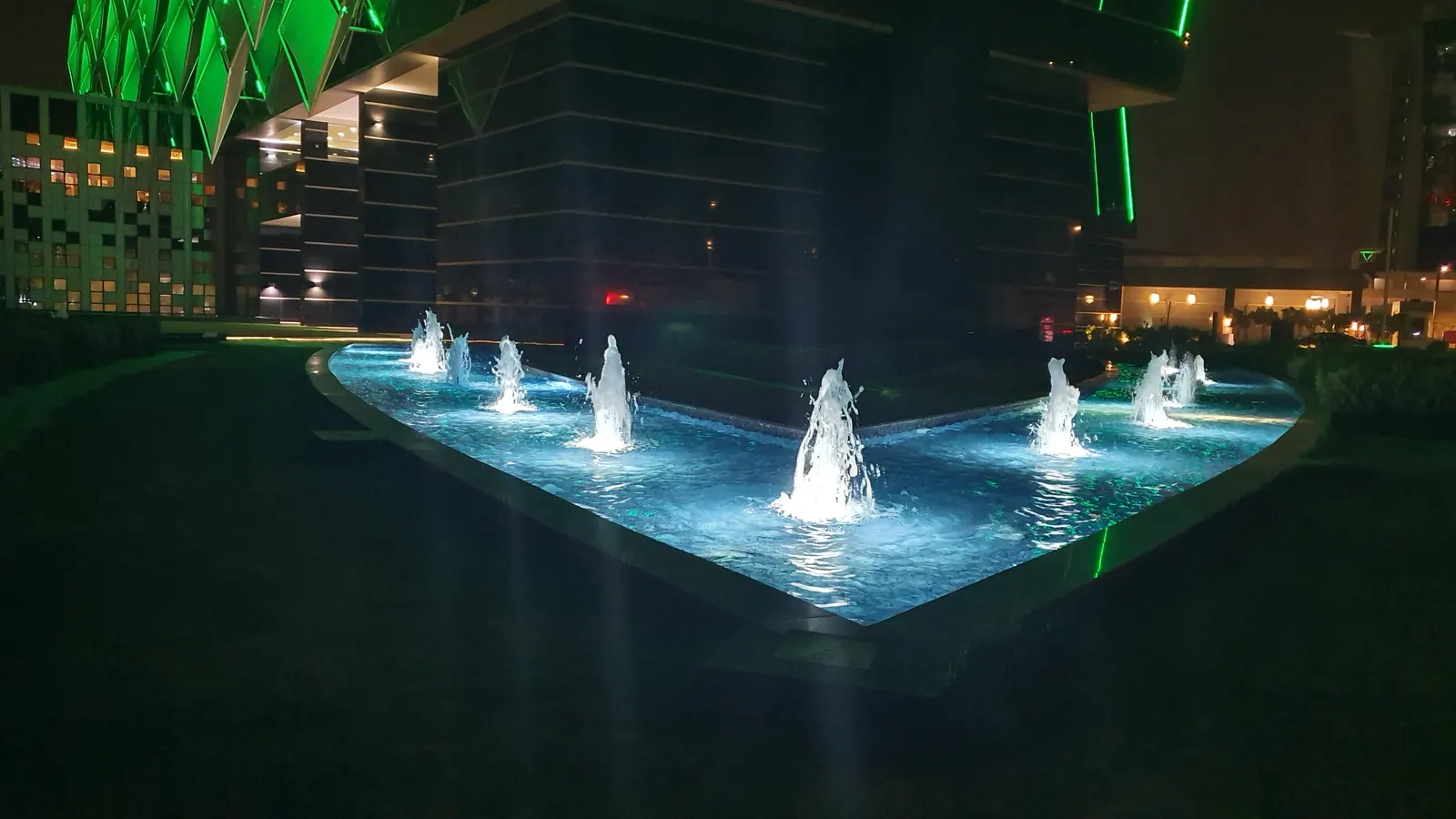 Fountain jets rising from the reflecting pool in front of the hotel