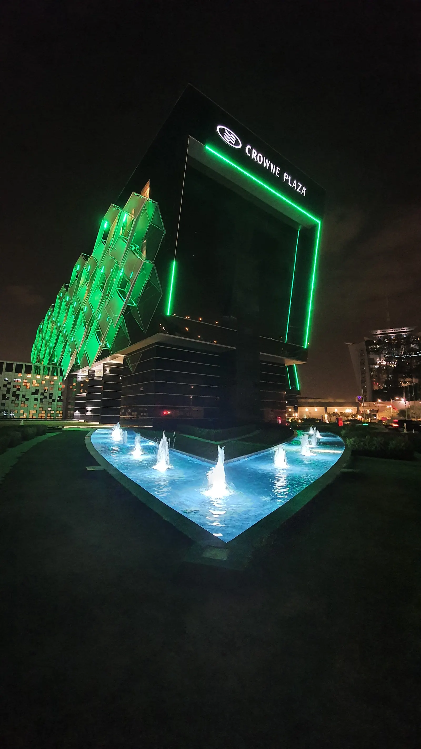 The hotel's tower above the lit fountain pool