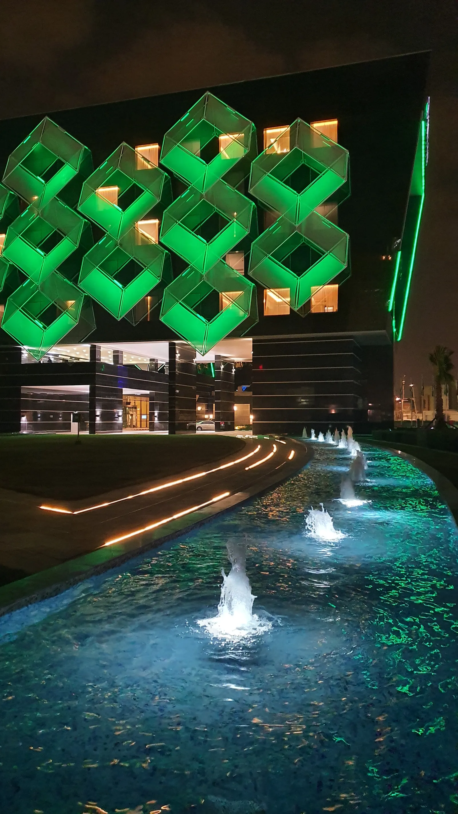 Water feature running along the hotel's patterned facade