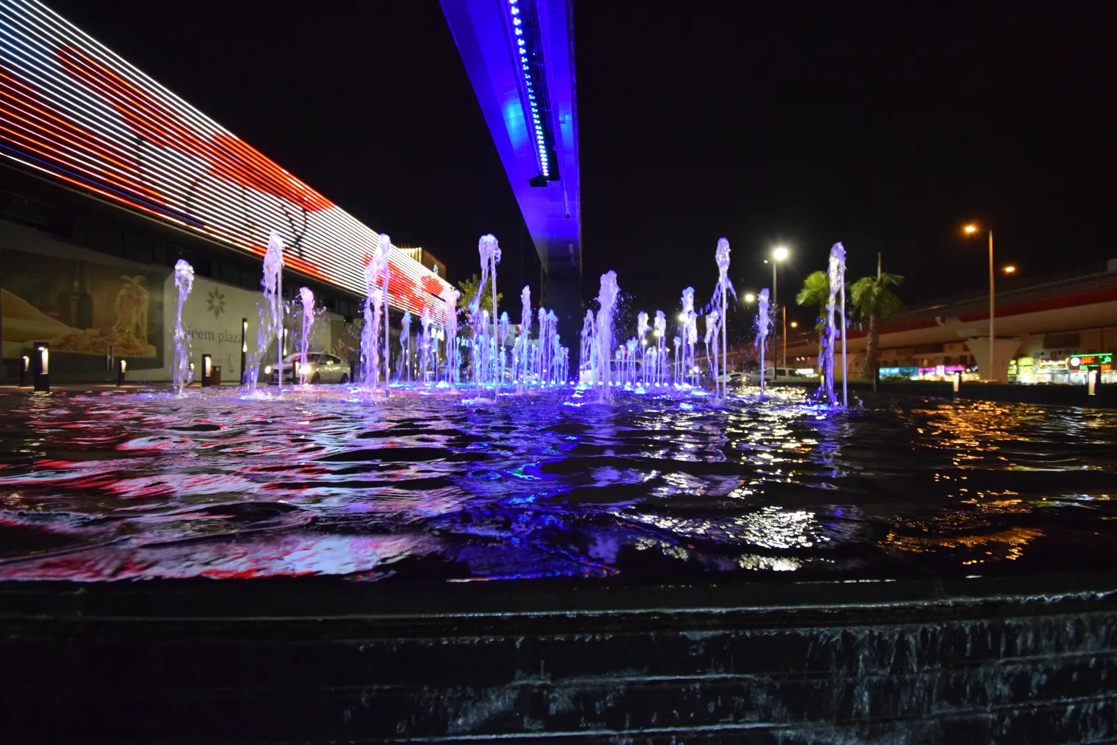 Dancing fountain lit in blue and purple at night