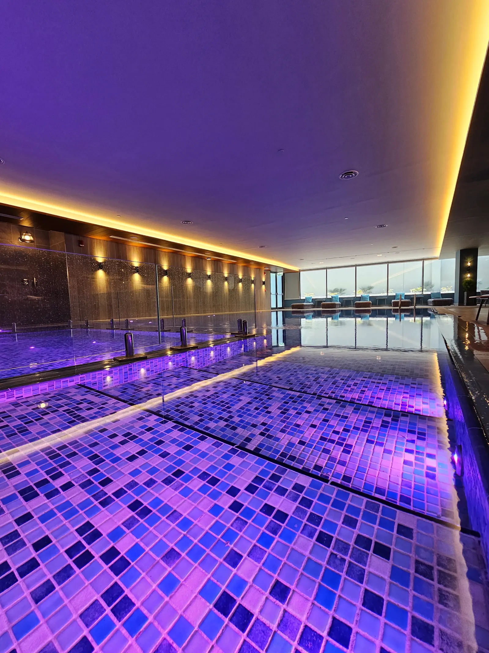 Indoor pool glowing under purple ambient light