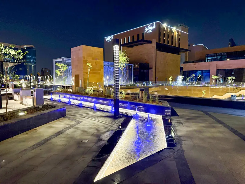 Illuminated fountain in a city square after dark