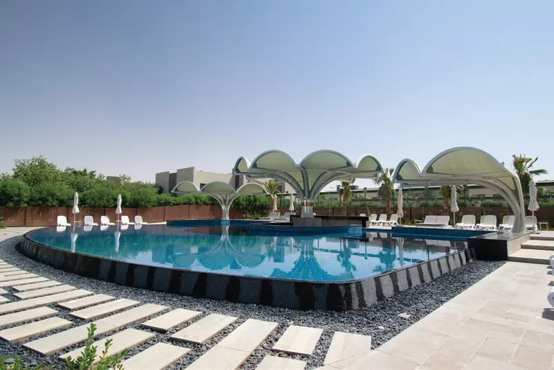 Hotel pool with shaded arches along the deck